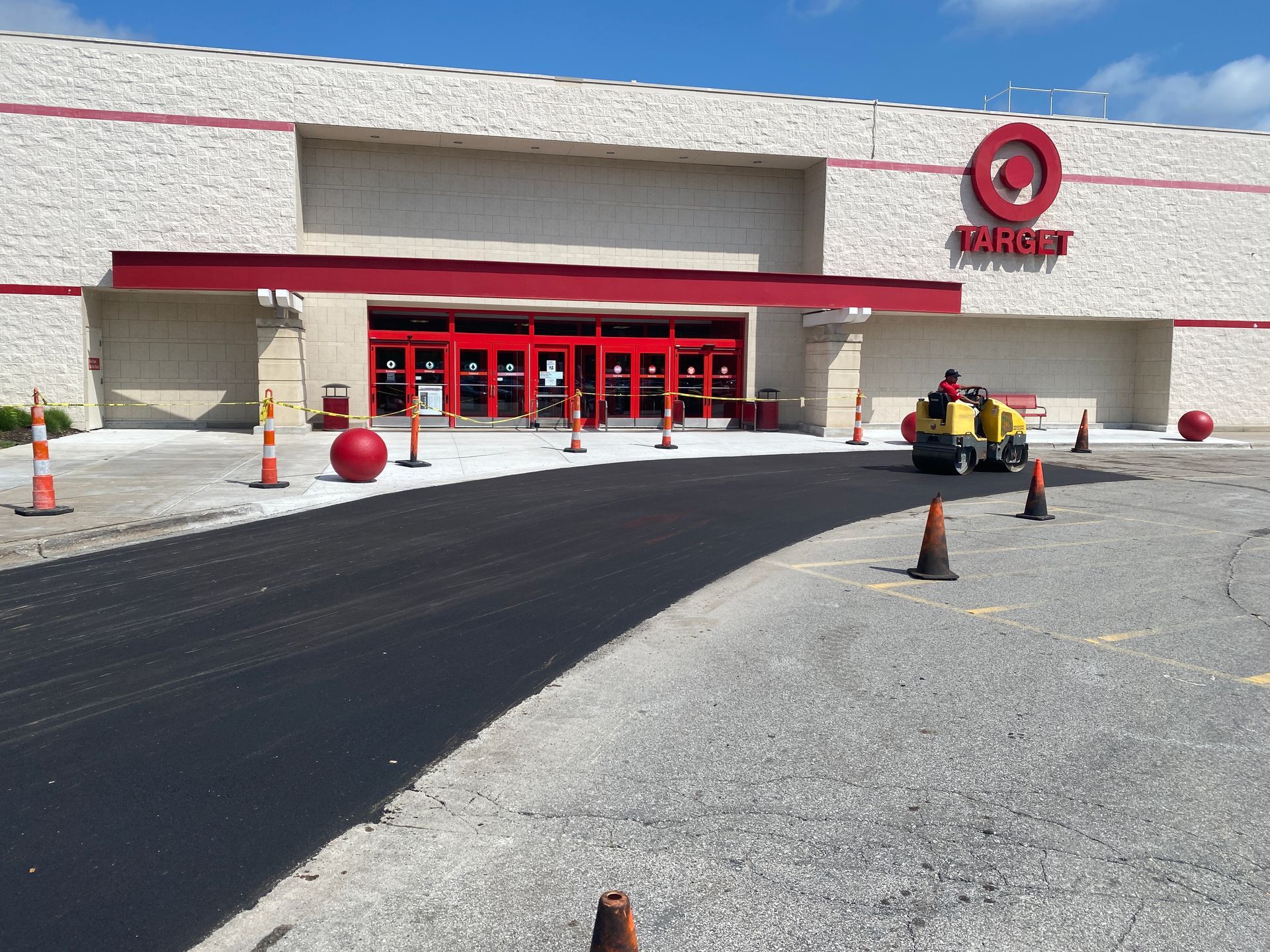 Blue IKEA store with a large, mostly empty parking lot under a clear blue sky.