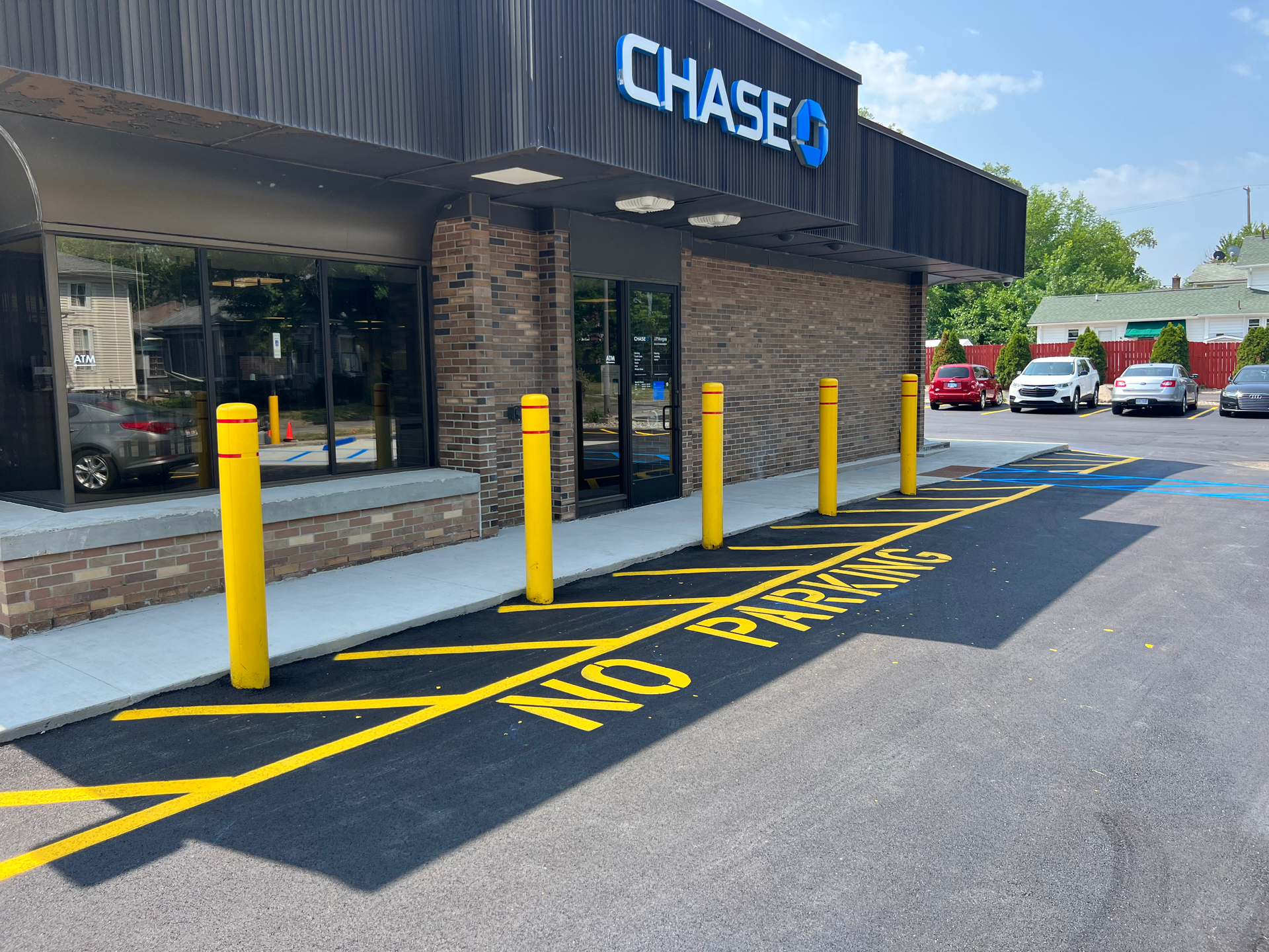 Asphalt truck spraying a new layer of asphalt on a residential street.