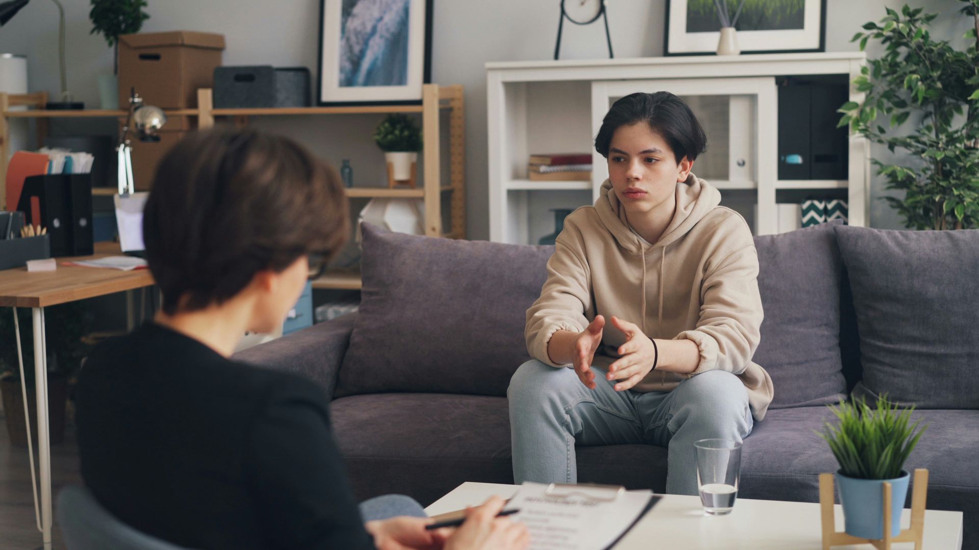 Person talking with a therapist on a couch in an office.