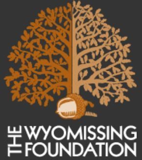Logo of The Wyomissing Foundation: A tree split into two halves, brown and orange, above text.