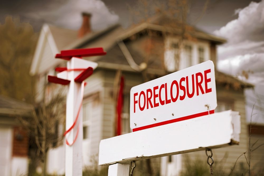 A foreclosure sign is in front of a house