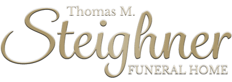 Logo for Thomas M. Steighner Funeral Home, with a cursive name in gold and &ldquo;FUNERAL HOME&rdquo; in gray.
