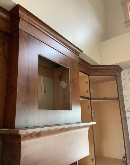 A wooden fireplace with a hole in the wall