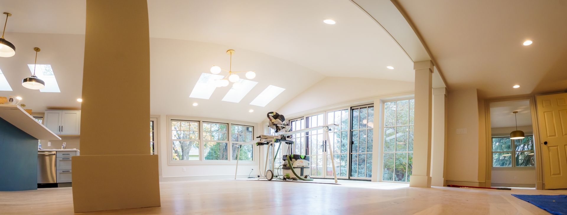 A large empty room with a lot of windows and a wooden floor.