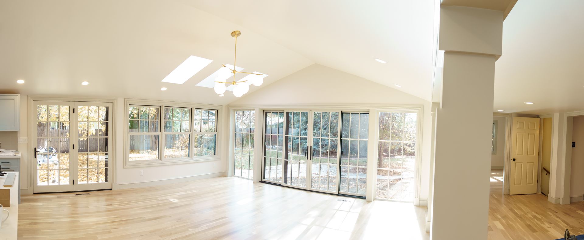 A large empty room with lots of windows and hardwood floors.