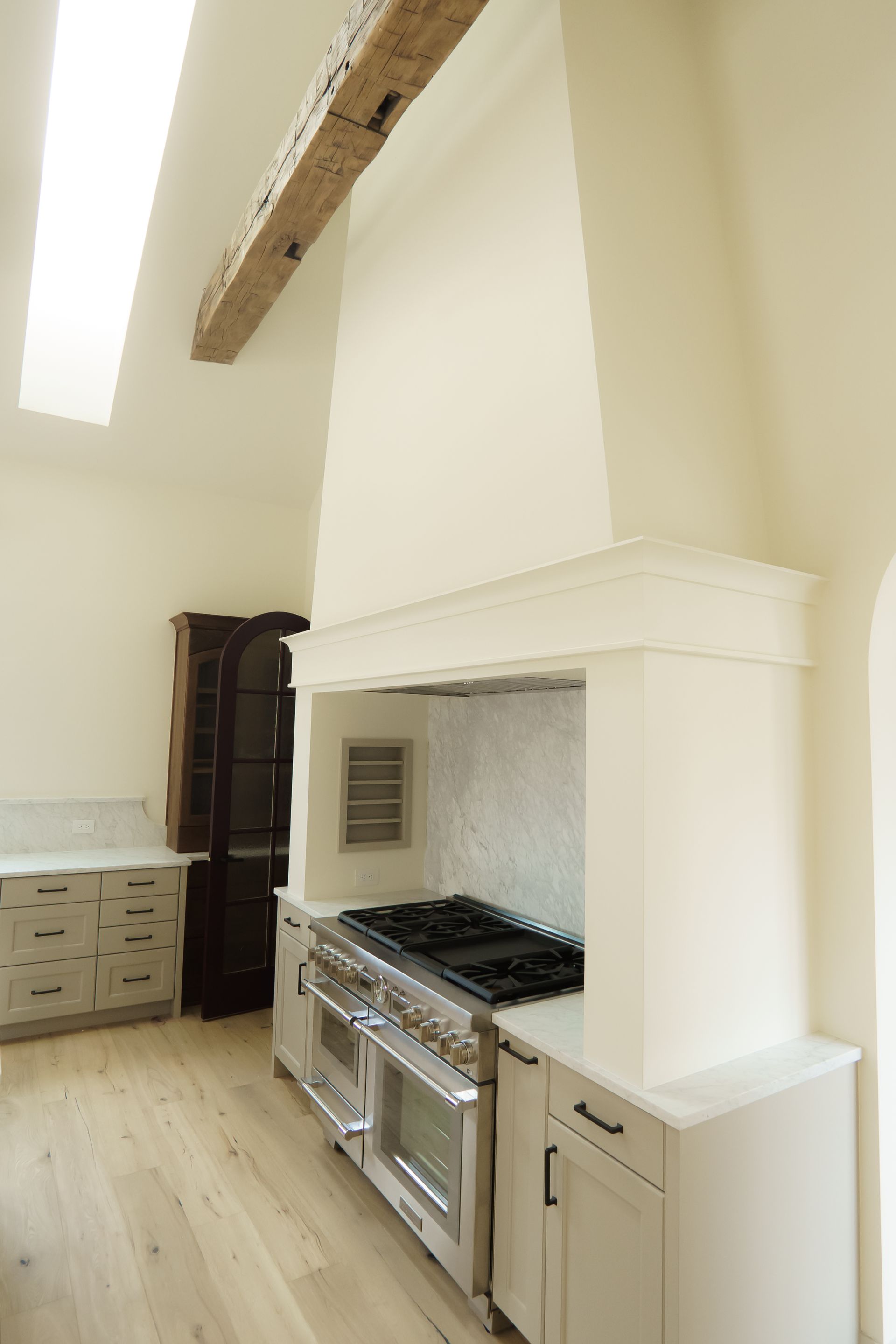 A kitchen with a stove , oven , and hood.