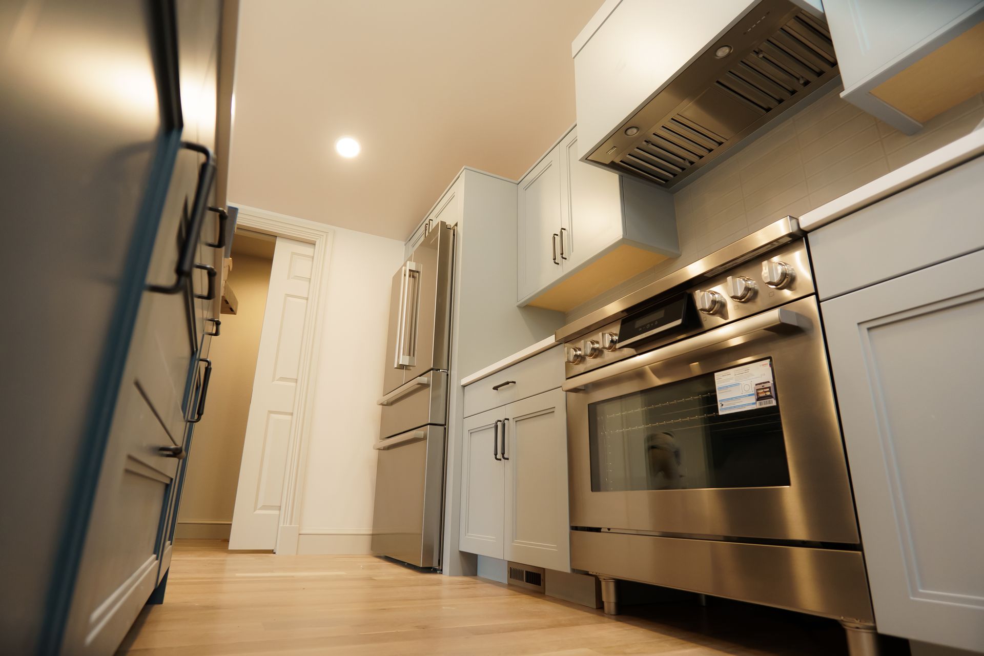 A kitchen with stainless steel appliances and white cabinets.