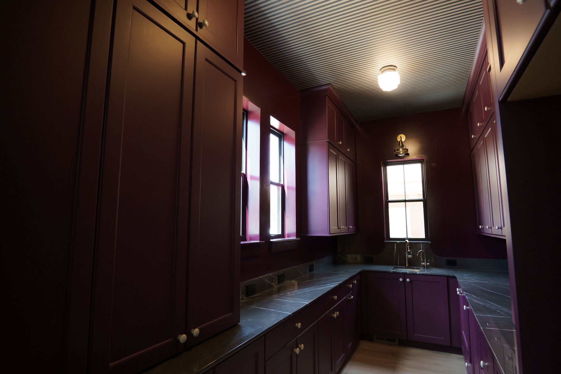 A kitchen with purple cabinets and a window