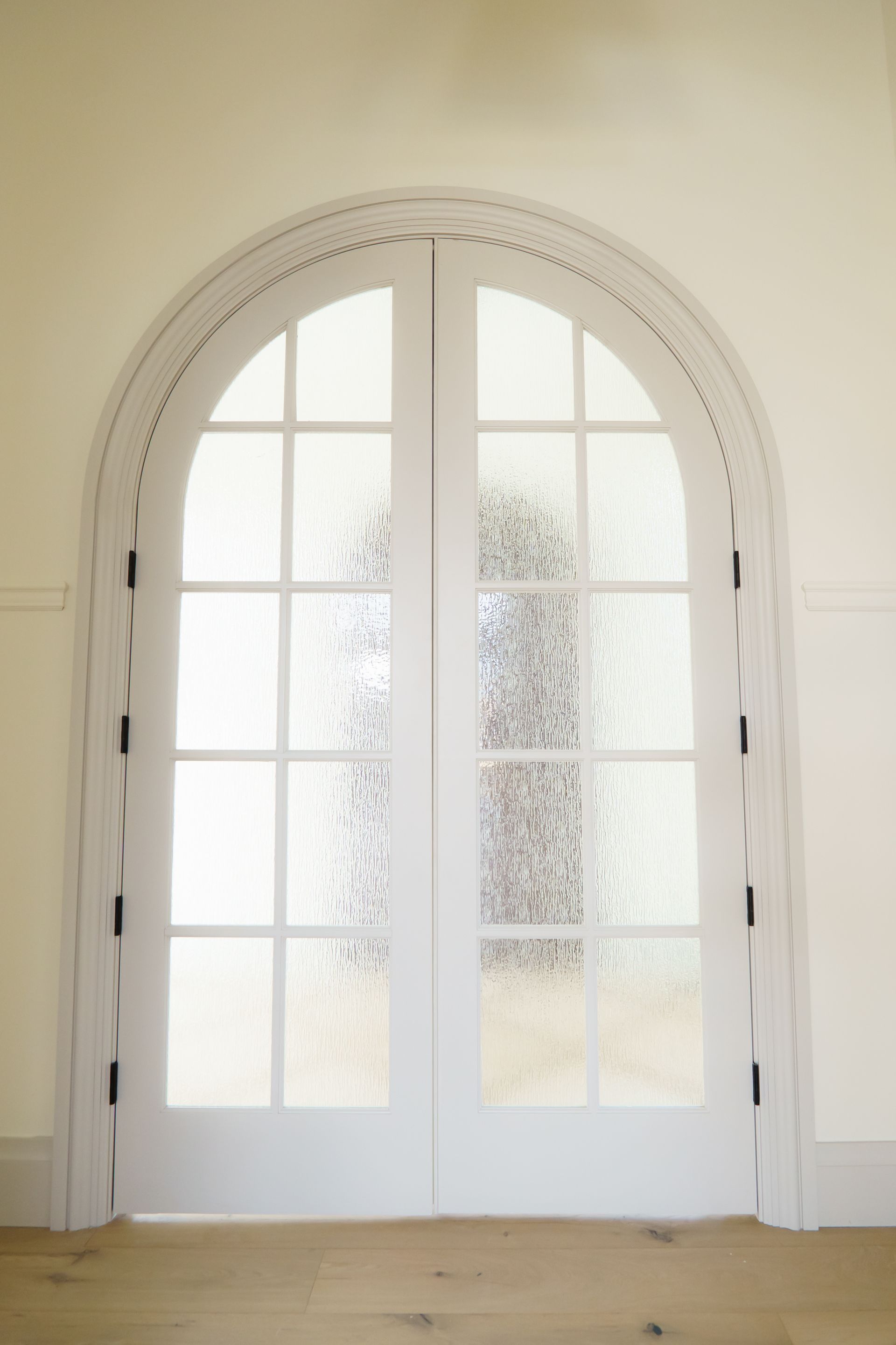 A white door with a glass window in a room.