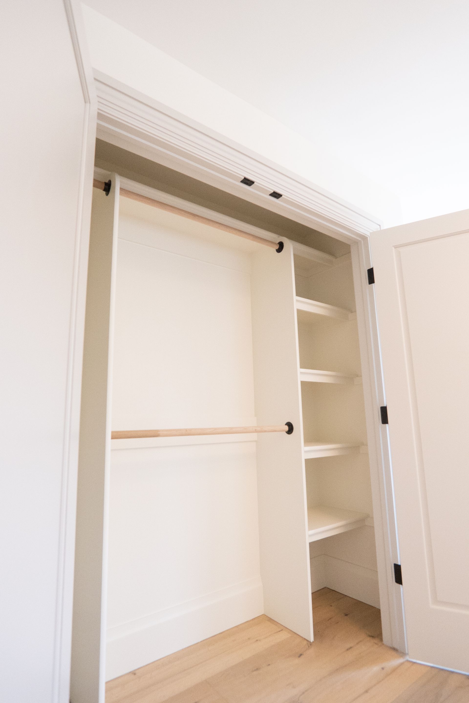 An empty closet with shelves and a hanging rail in a bedroom.