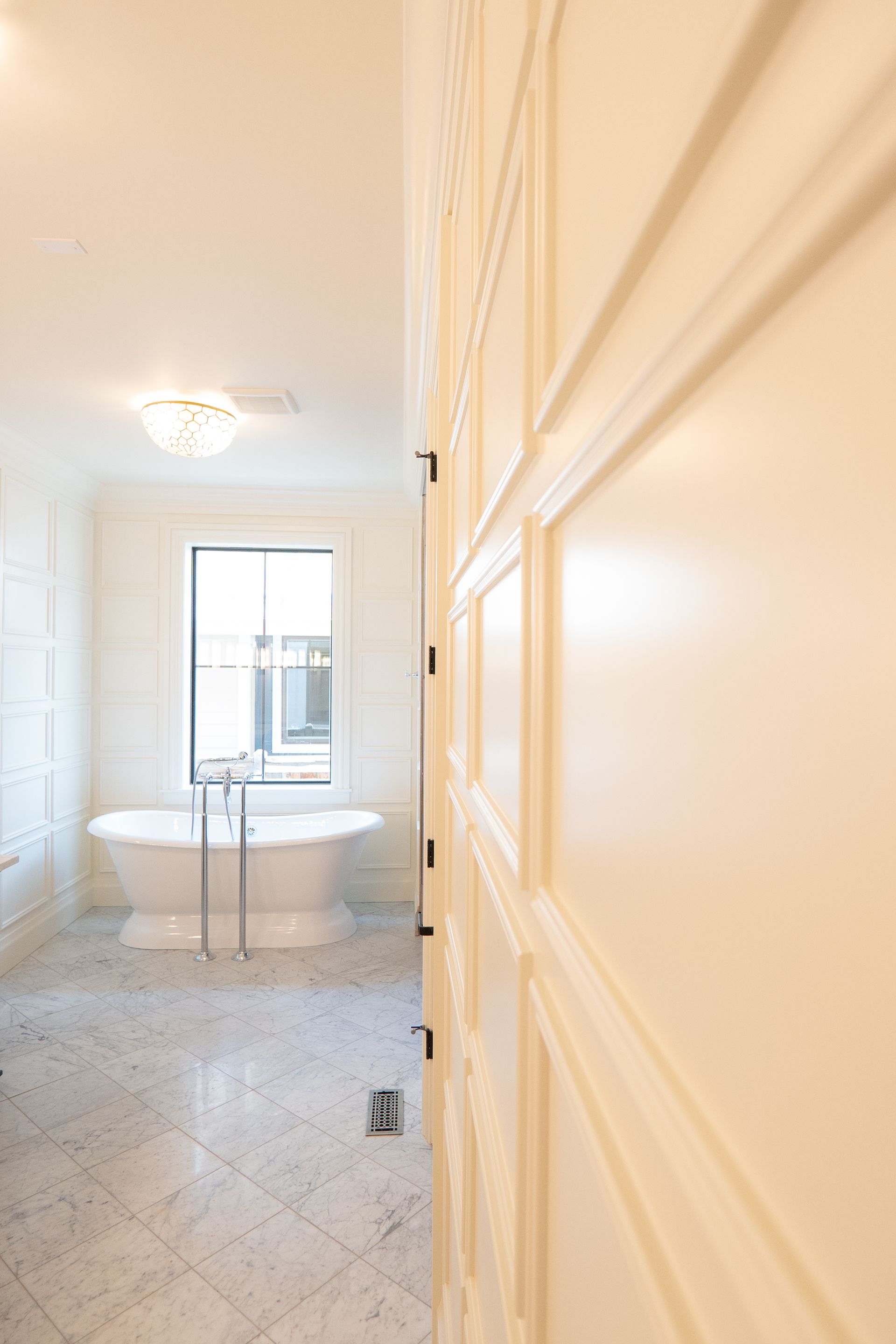 A bathroom with two tubs and a window.