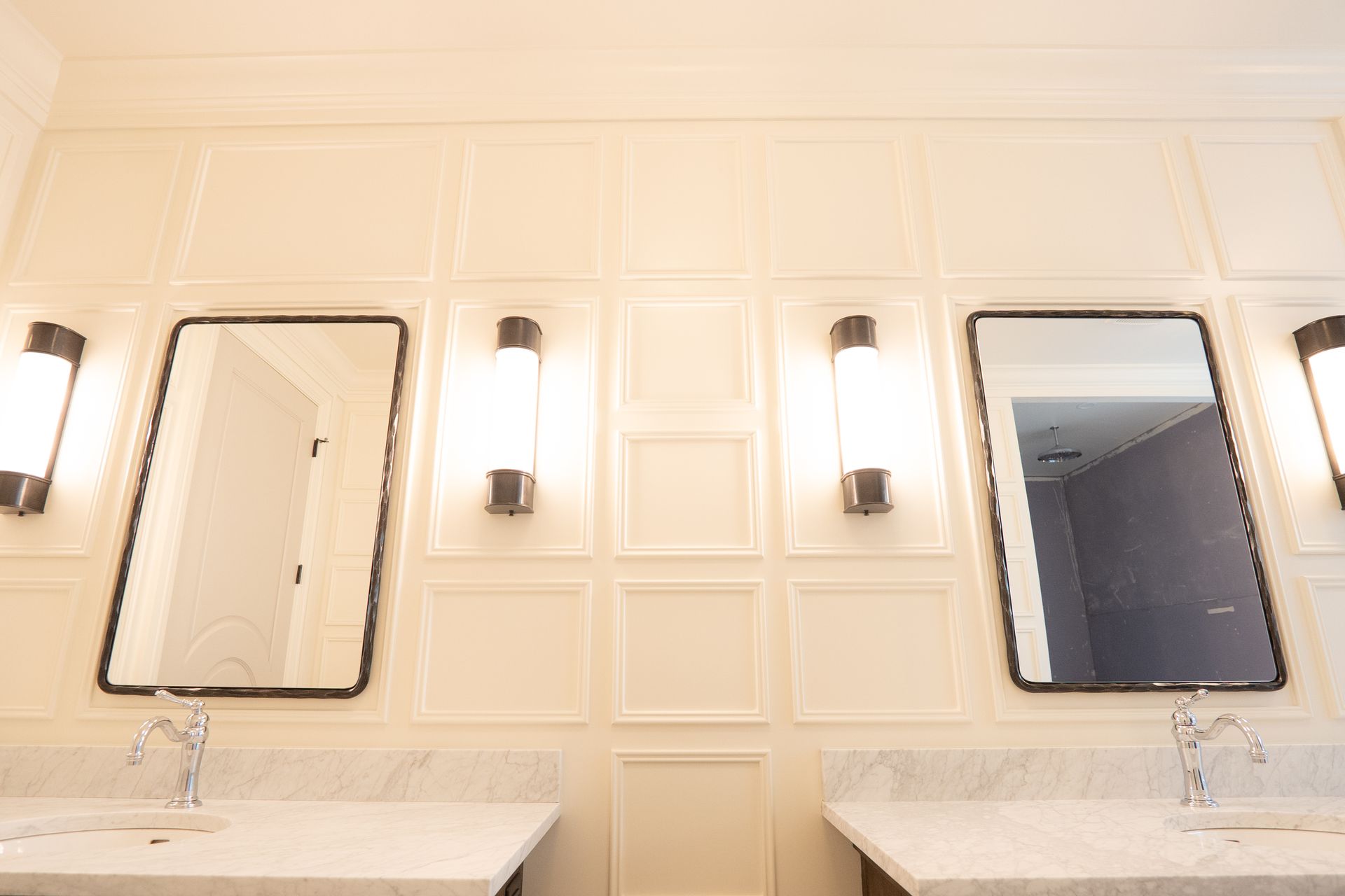 A bathroom with two sinks and two mirrors on the wall.