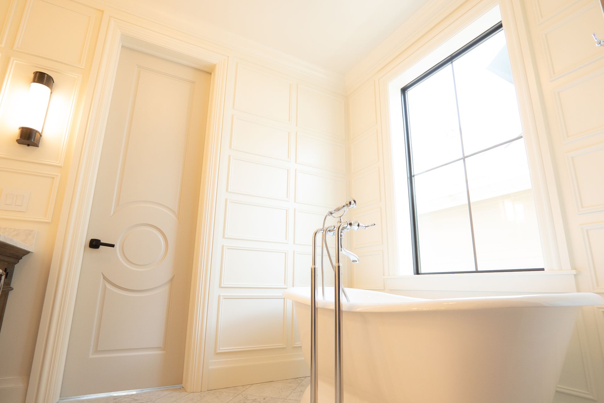 A bathroom with a tub and a window.