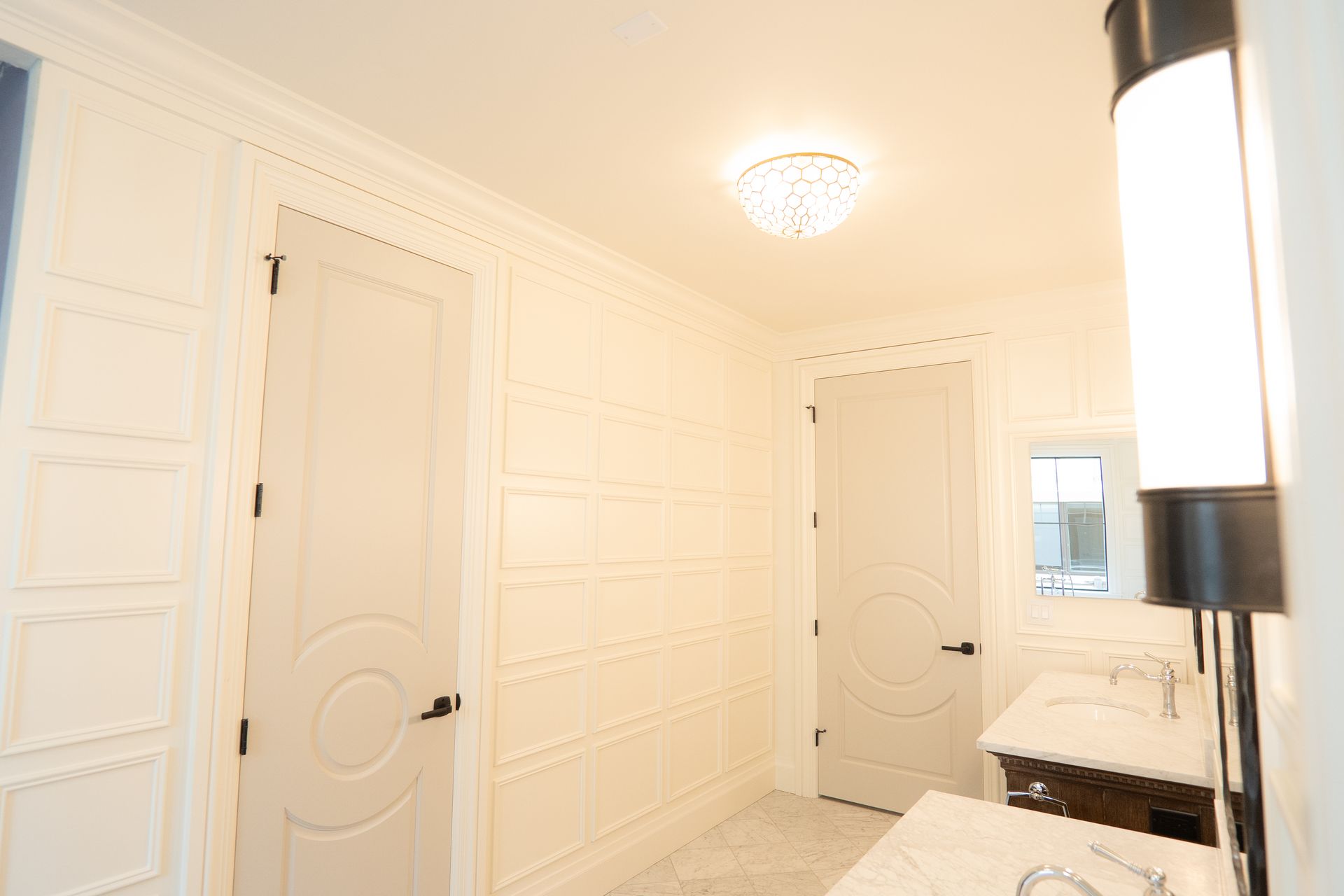 A bathroom with two sinks , a mirror and a lamp.