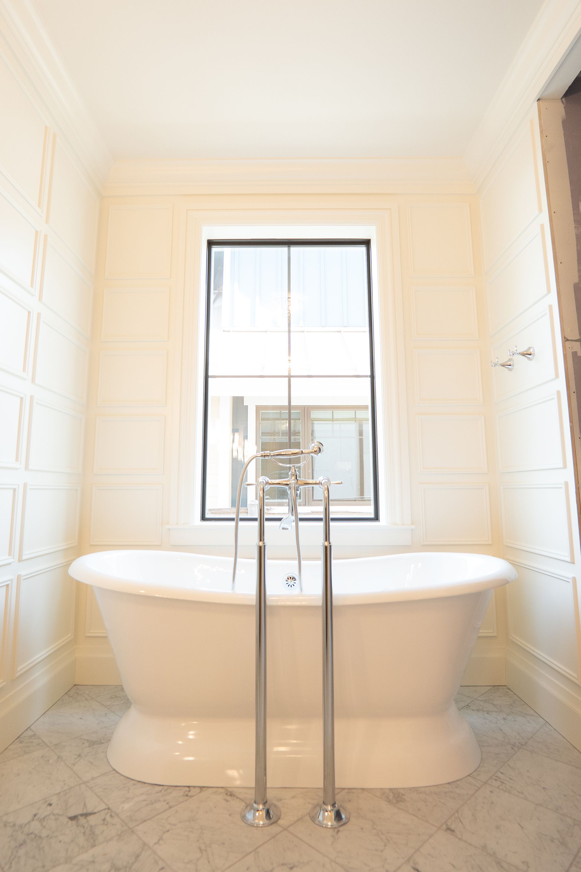 A bathroom with a bathtub and a window.