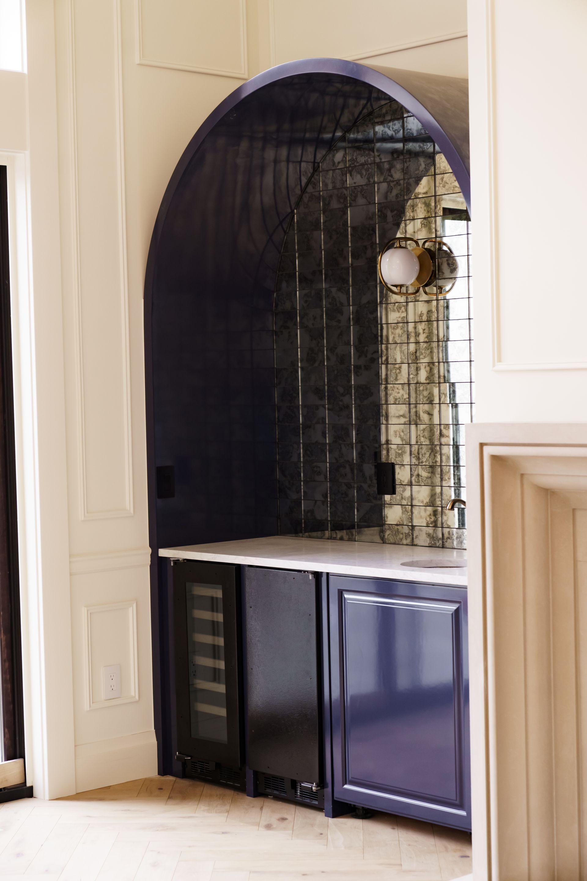 A kitchen with blue cabinets and a wine cooler.
