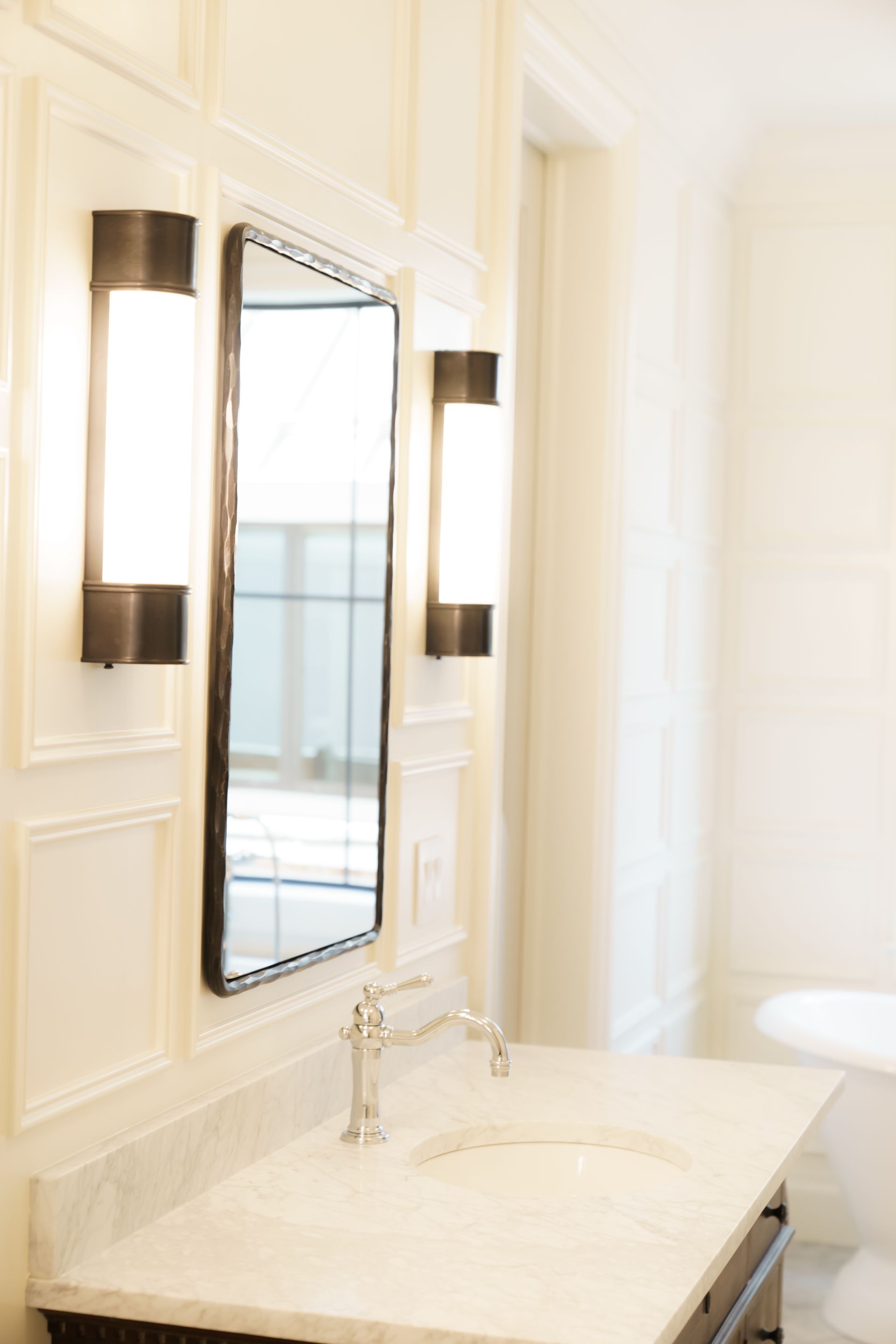 A bathroom with a sink , mirror and lights