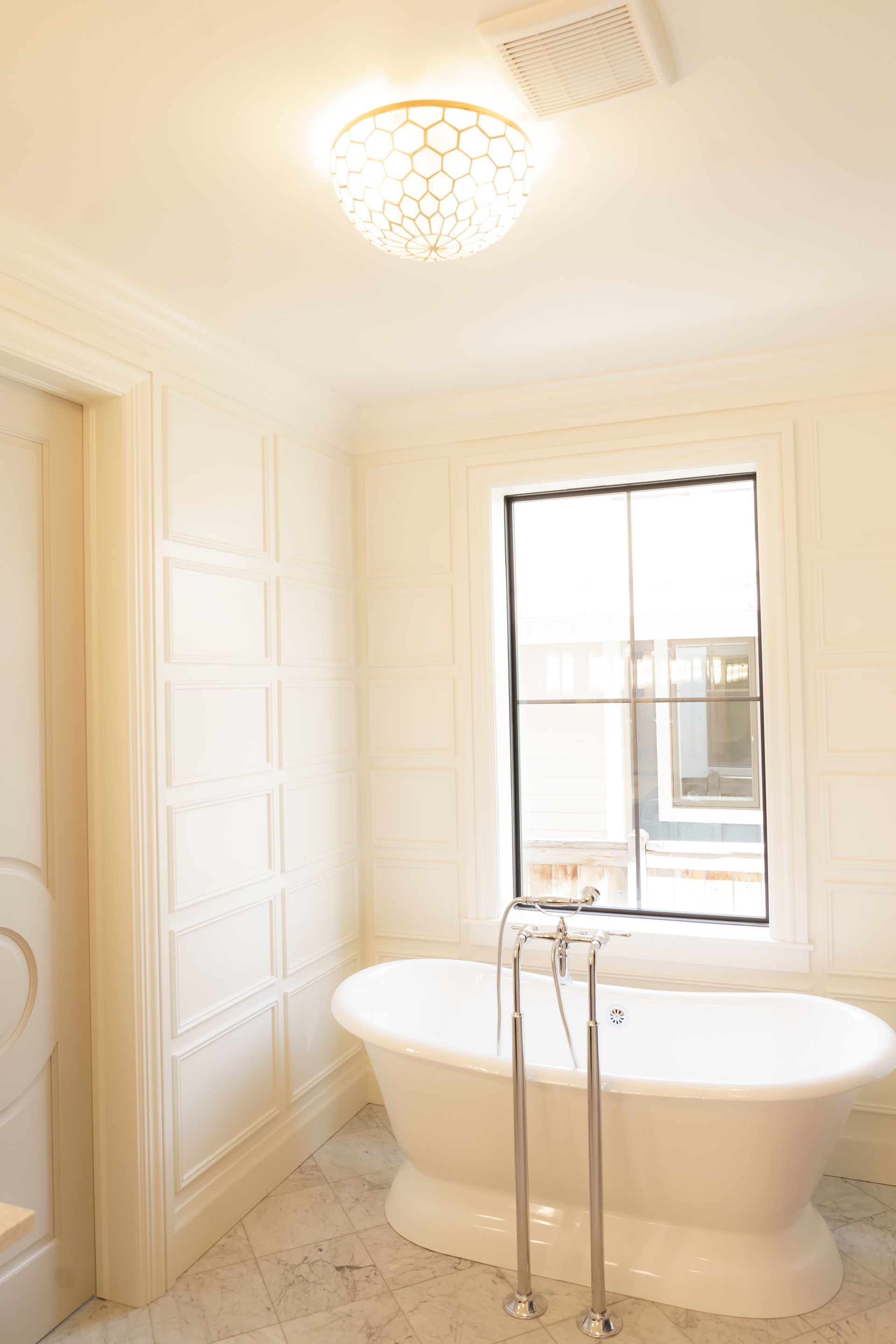 A bathroom with a tub and a window.
