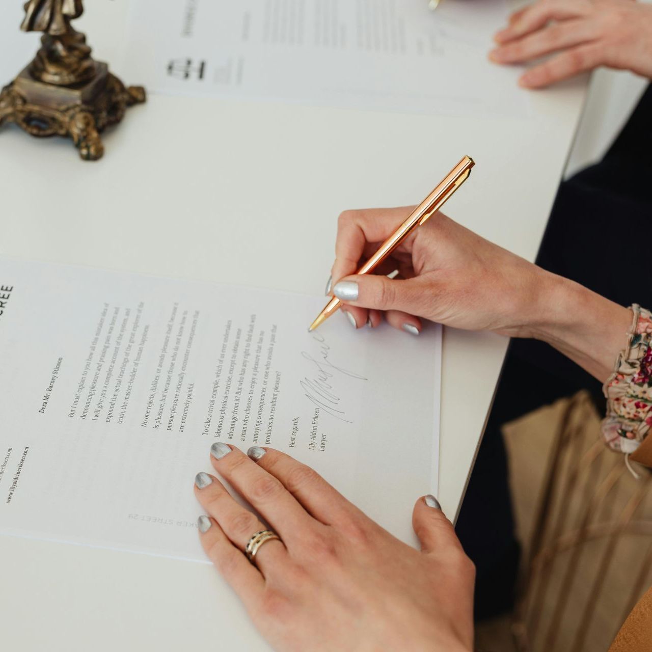 A woman is writing on a piece of paper with a pen