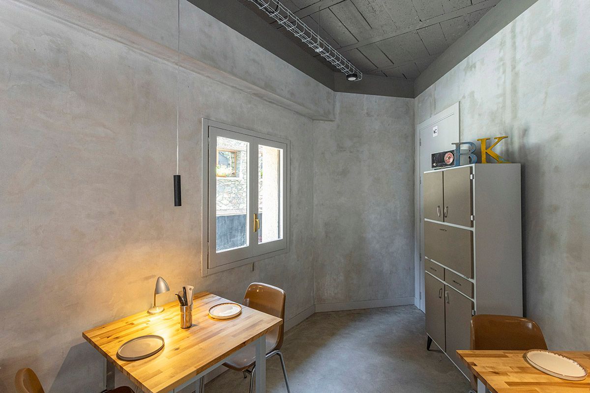 Fotografia Emfasi Estudi Andorra. Un comedor con mesa y sillas y refrigerador.
