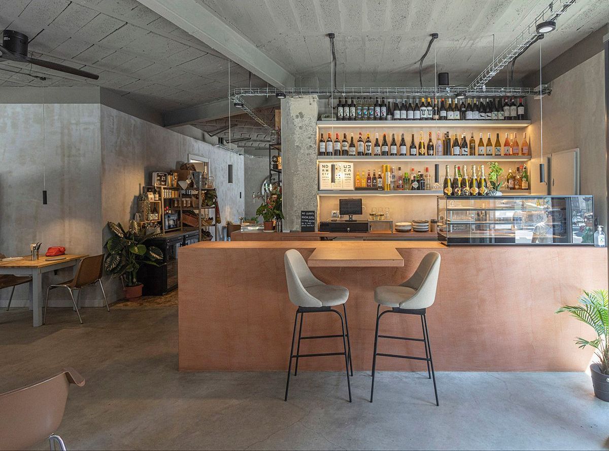 Fotografia Emfasi Estudi Andorra. Una barra con dos taburetes y una mesa en un restaurante.
