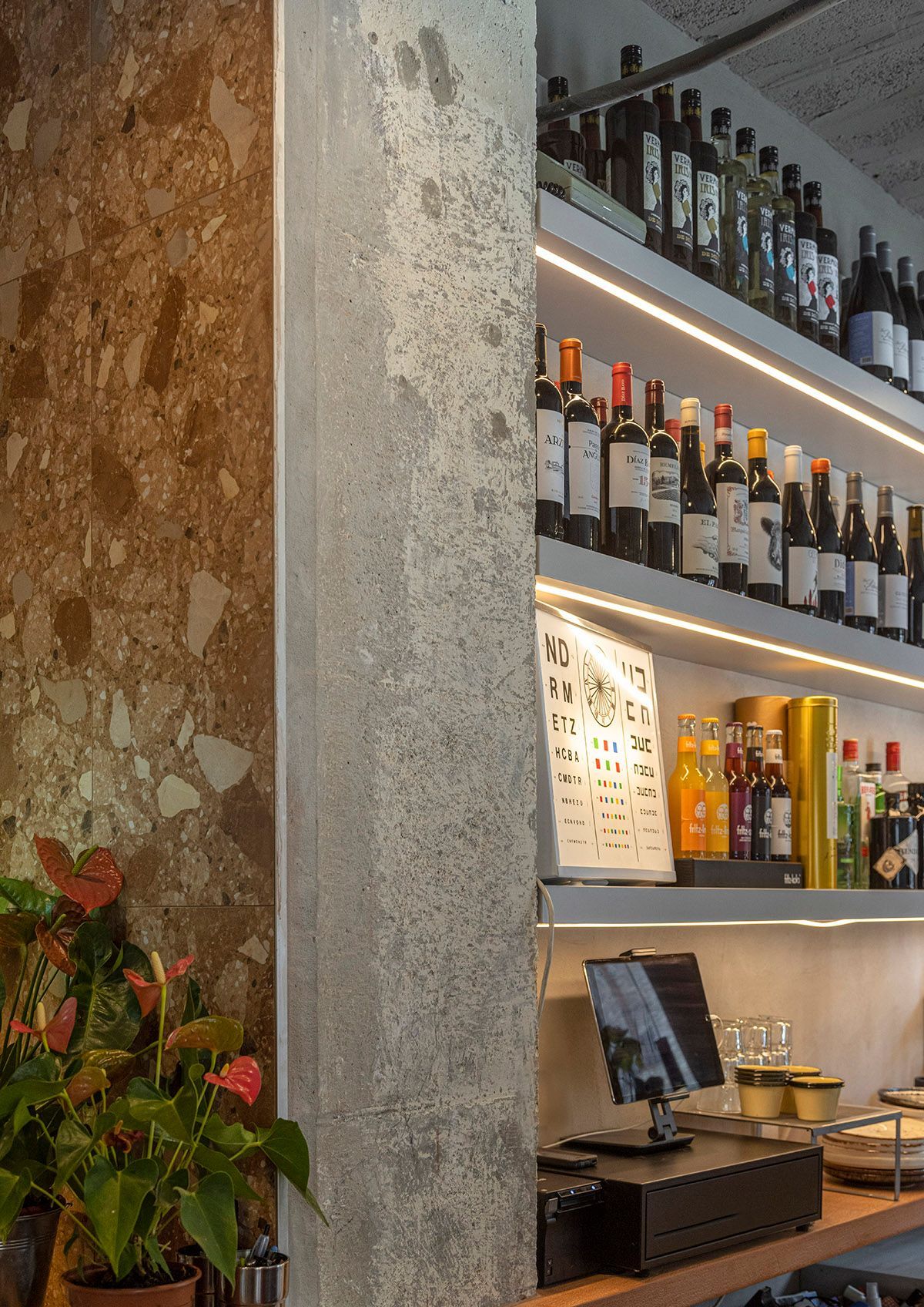 Fotografia Emfasi Estudi Andorra. Un bar con muchas botellas de vino en los estantes.