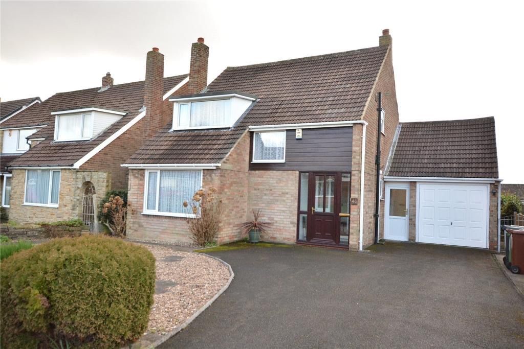 House with attached garage and driveway. Brick and brown siding exterior.