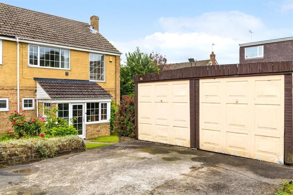 Two-story yellow brick house with a driveway and attached double garage. Blue sky overhead.