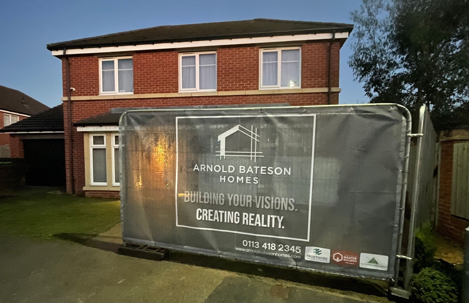 A brick house with a construction banner that says