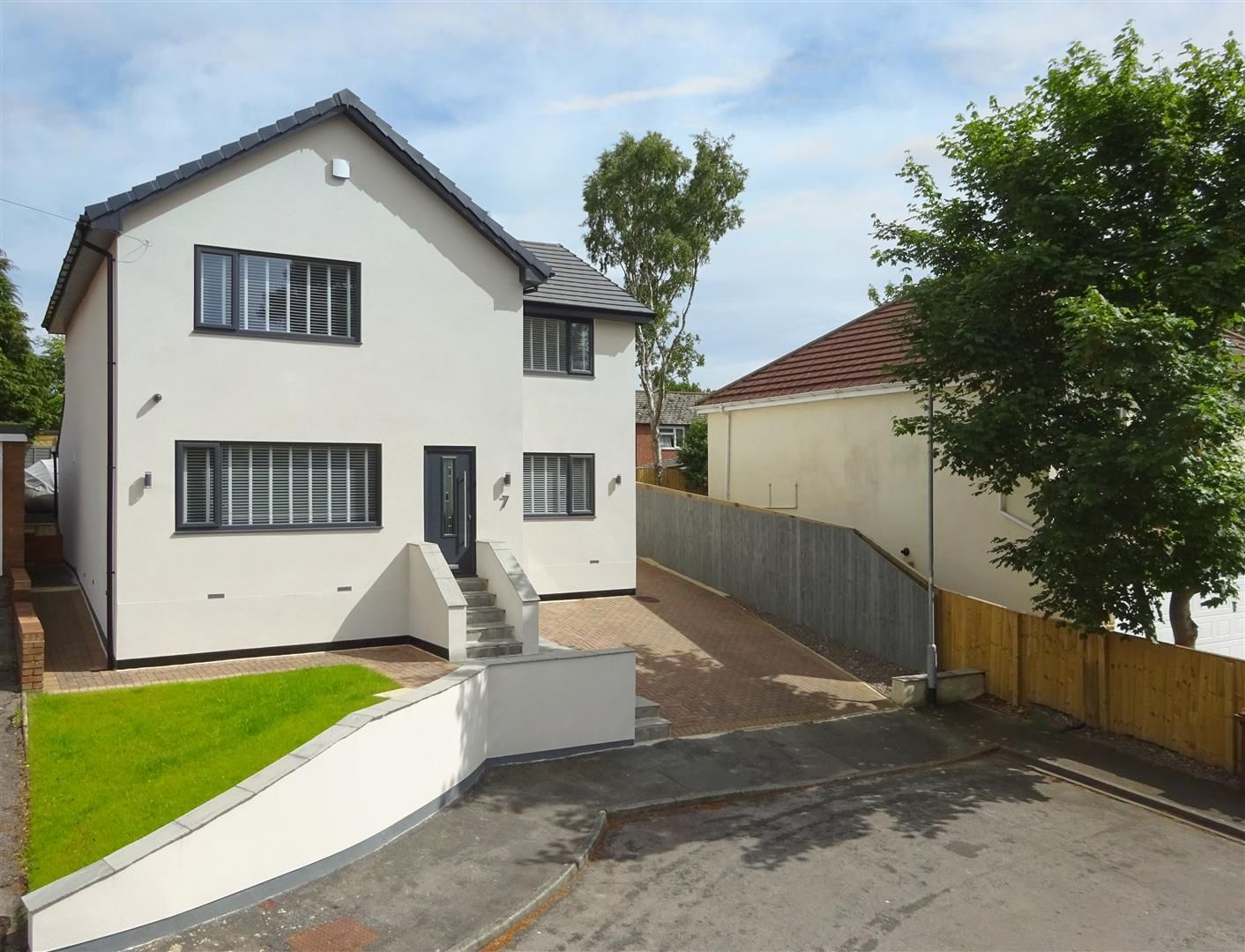 Modern two-story house with a white exterior, black trim, and a small front yard.