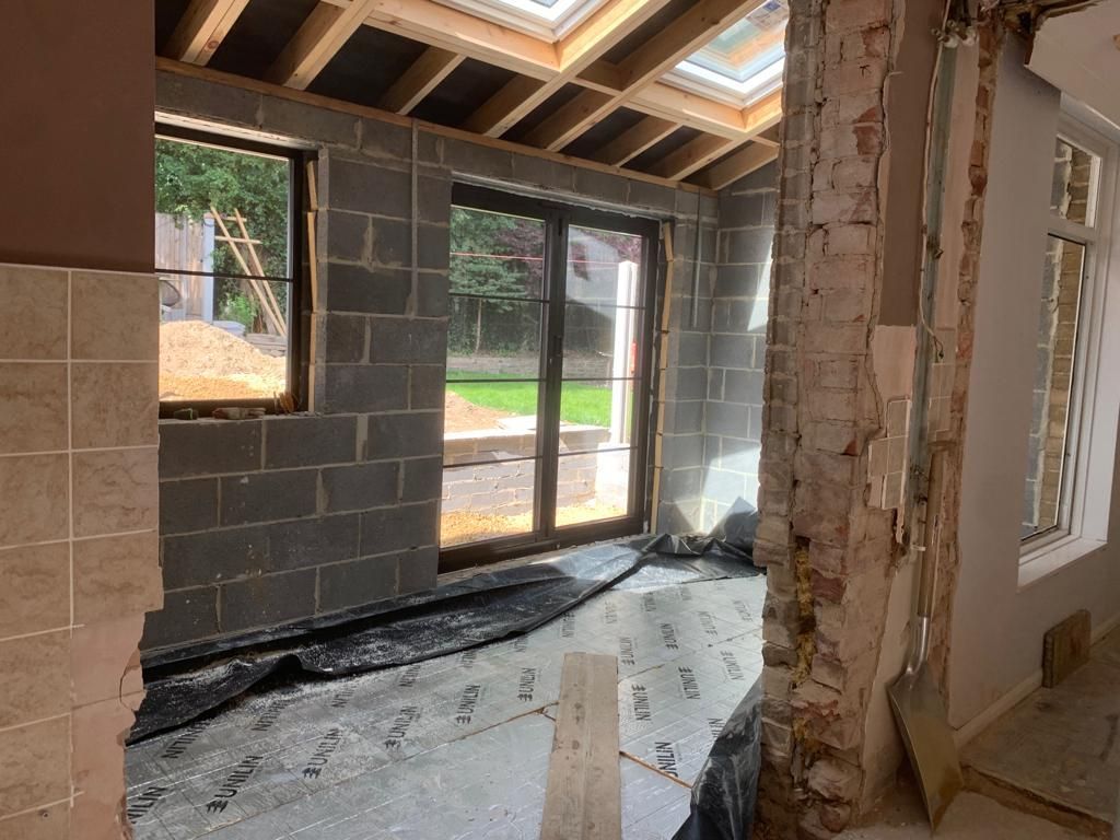 Interior of a room under construction. Block walls, new windows and a sliding glass door.