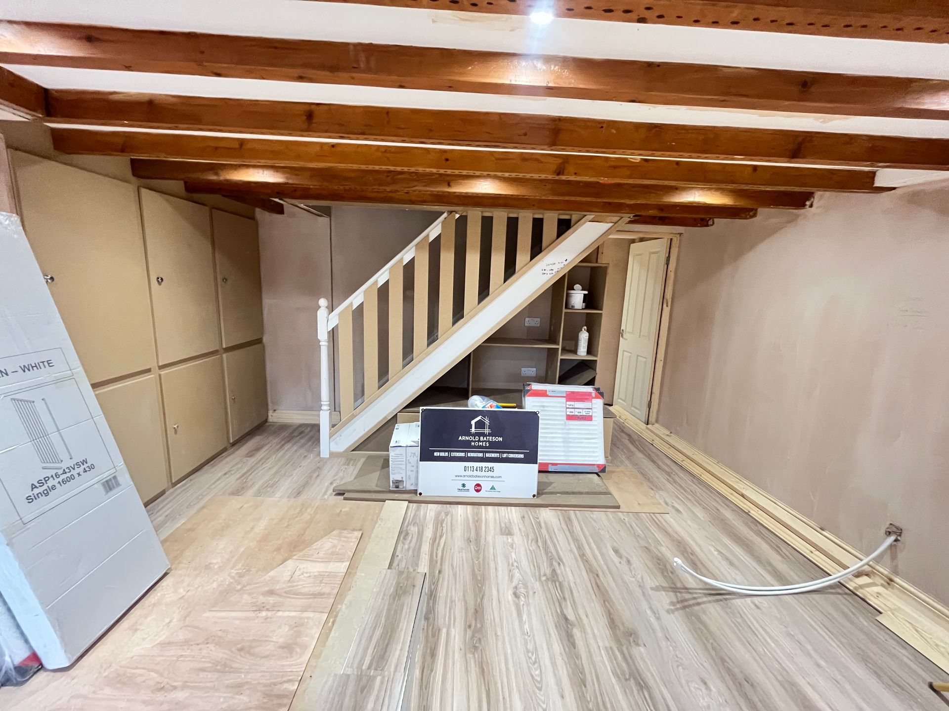 Renovated interior with staircase, wooden beams, new flooring, and built-in storage.