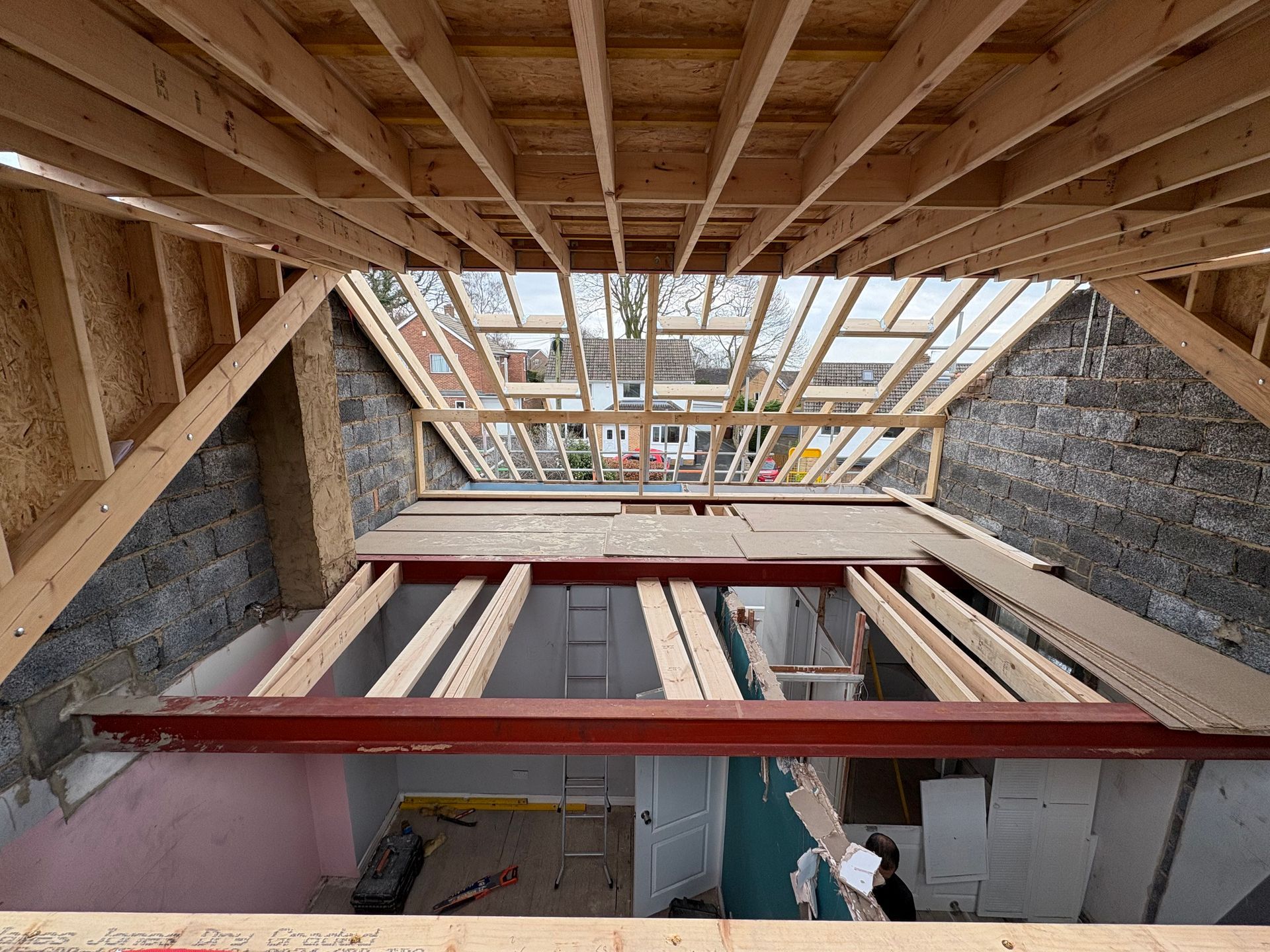 Construction of a new roof. Interior view, exposed beams, steel support, brick walls, natural light.