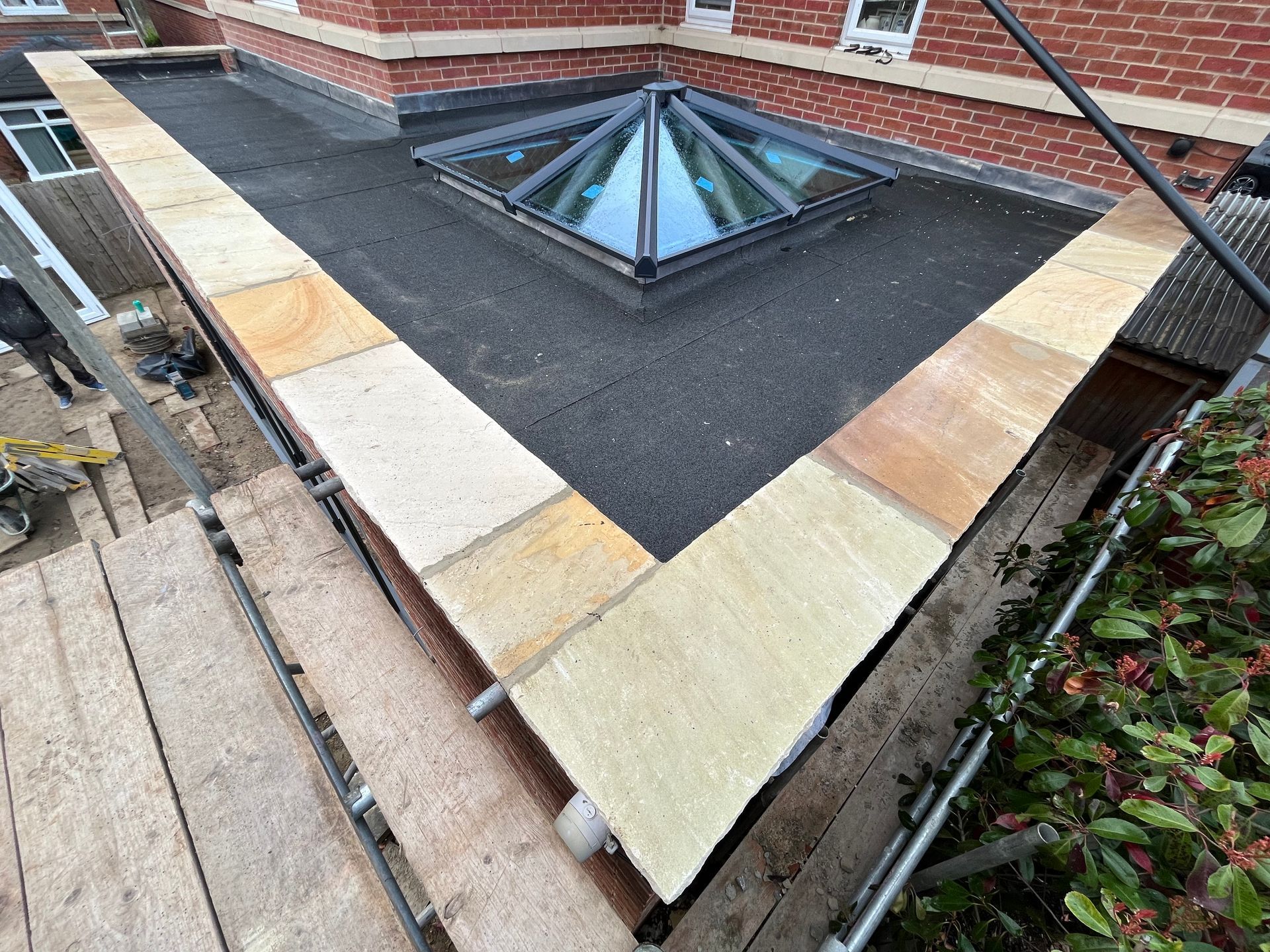 A flat roof with sandstone edging, featuring a skylight.