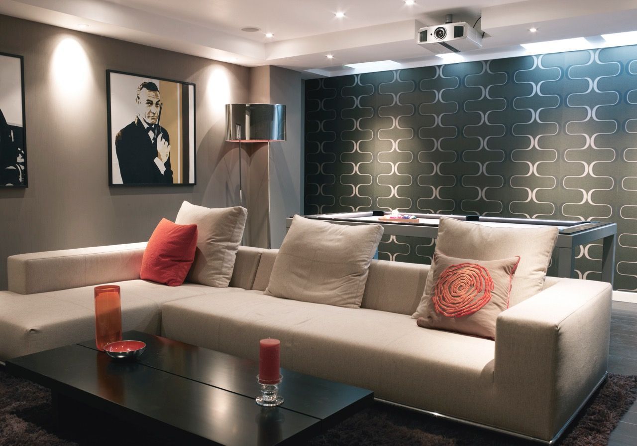 Modern home theater with cream sectional sofa, black coffee table, and wall art.