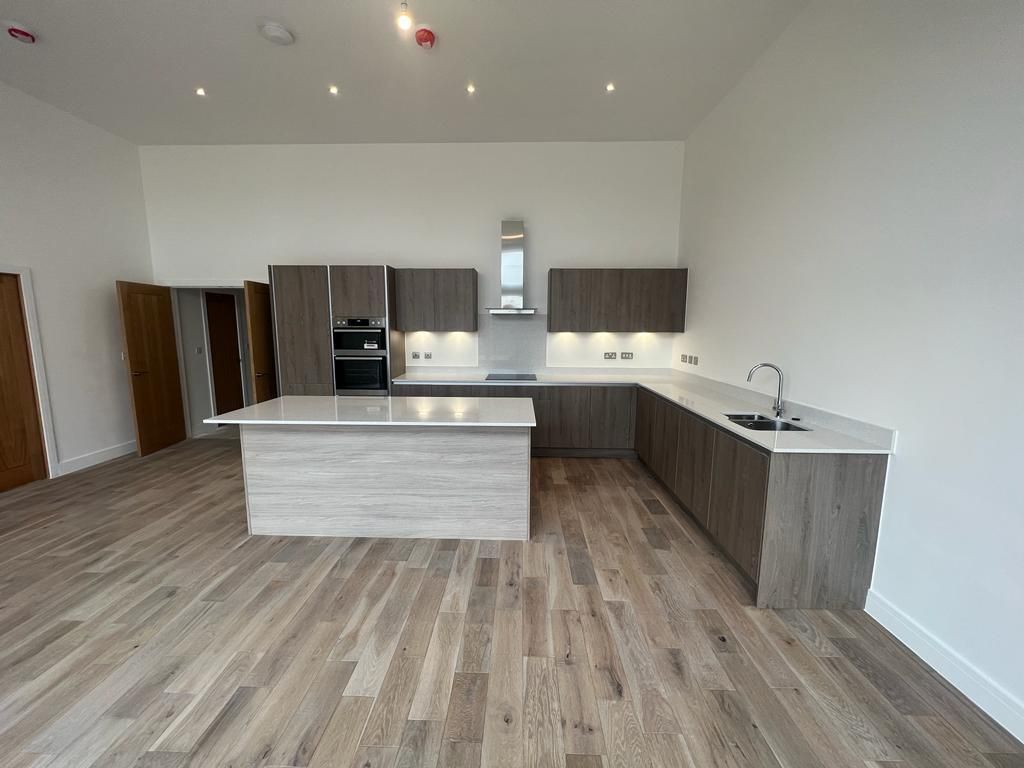 Modern kitchen with wood cabinets, white countertops, and a central island.