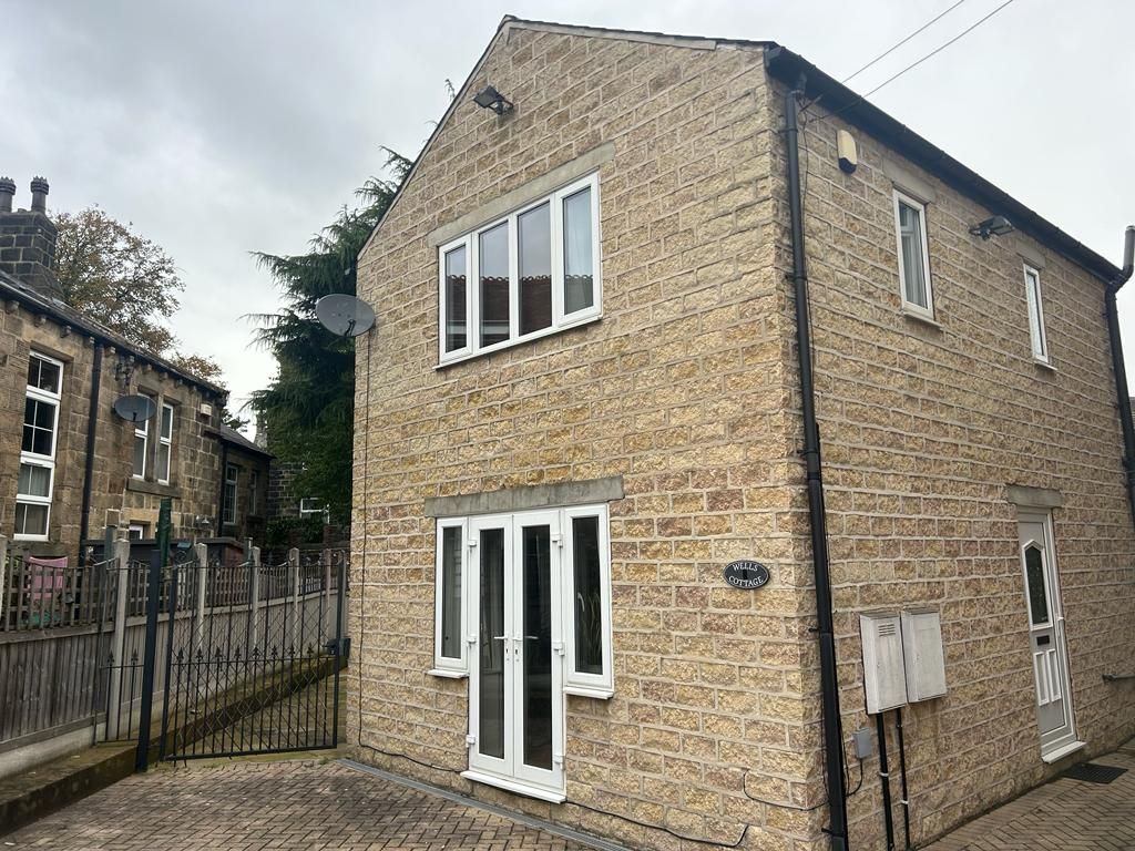 Two-story stone house with white-framed windows and doors. A second house is visible to the left.