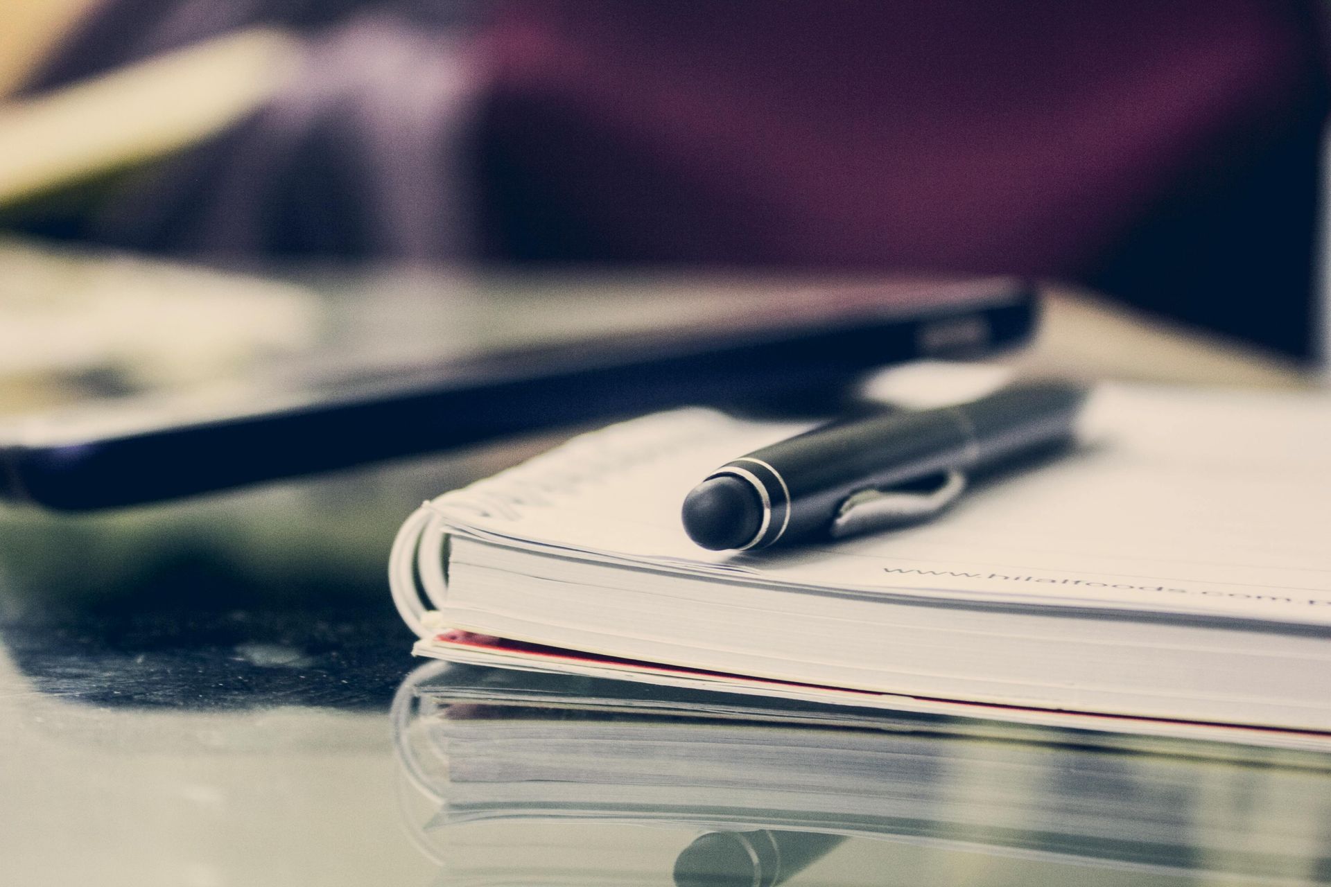 A pen is sitting on top of a notebook representing estate planning notes.