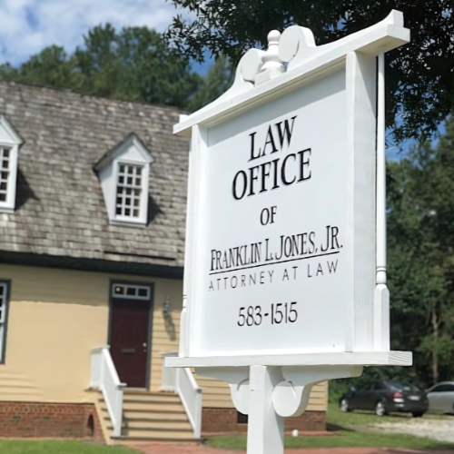 Sign for Law Office of Franklin L. Jones Jr. in front of a light yellow building with a red door.