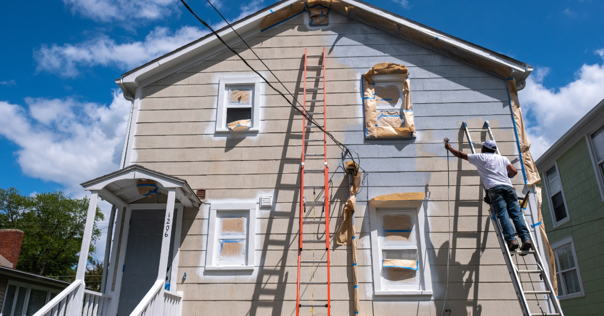 Wooden porch with hanging flower baskets and a lounge chair.