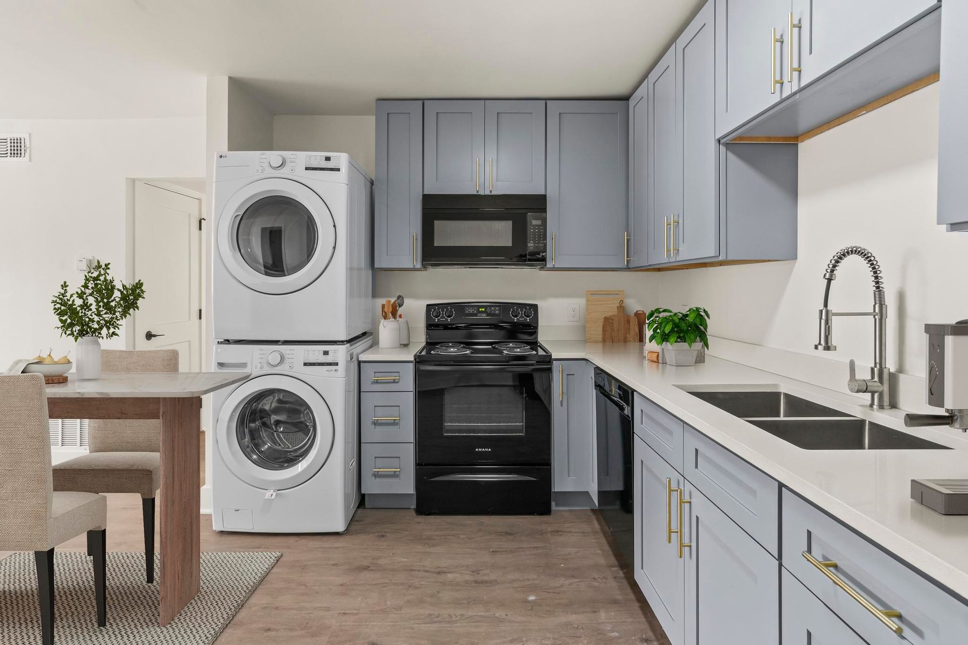 A kitchen with a washer and dryer stacked on top of each other.