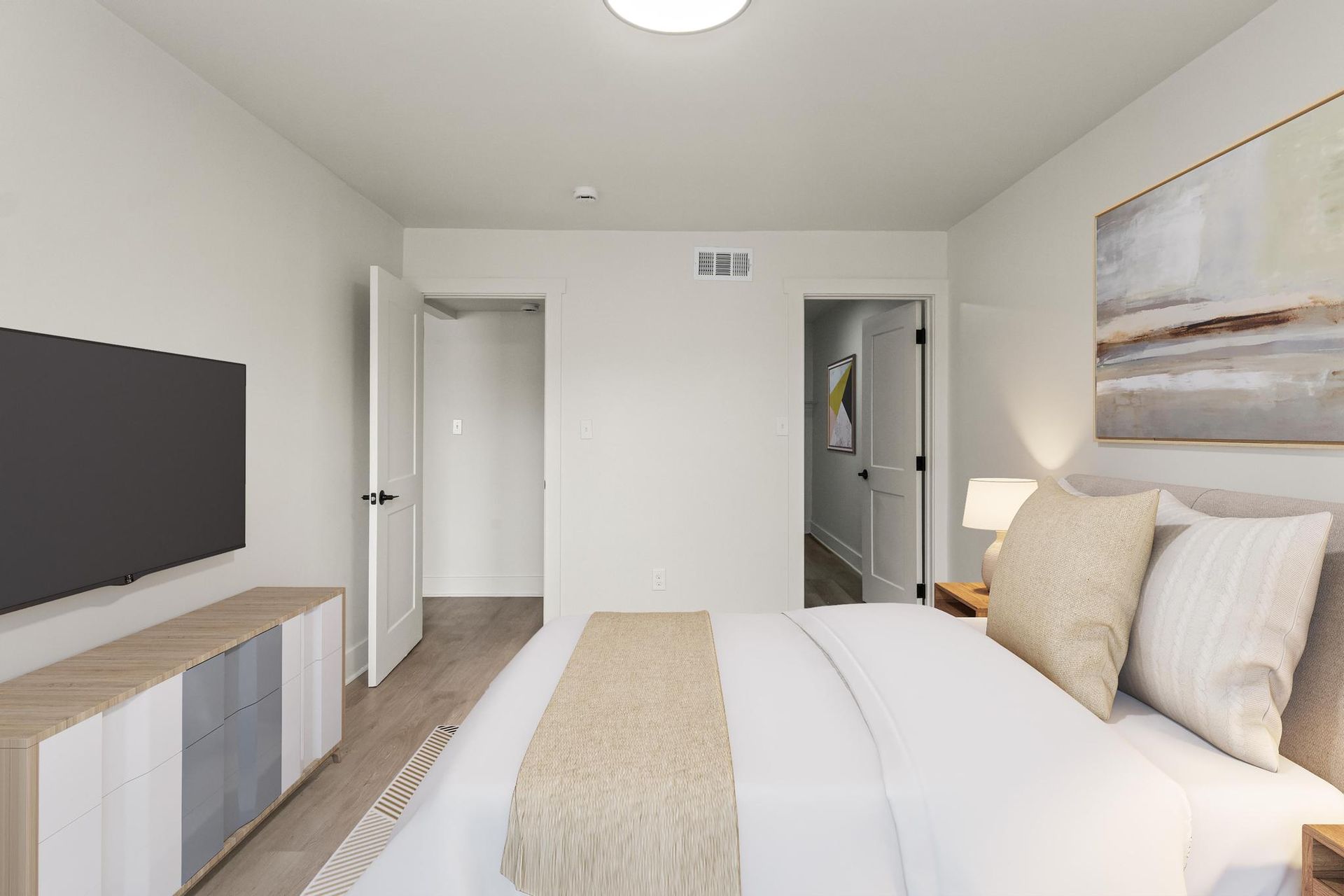 A bedroom with a large bed and a flat screen tv