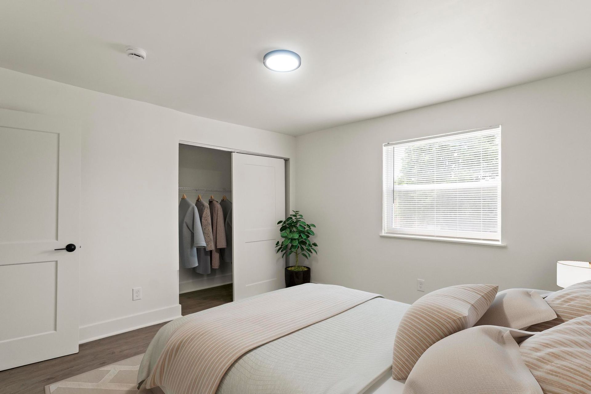A bedroom with a bed , window and closet.