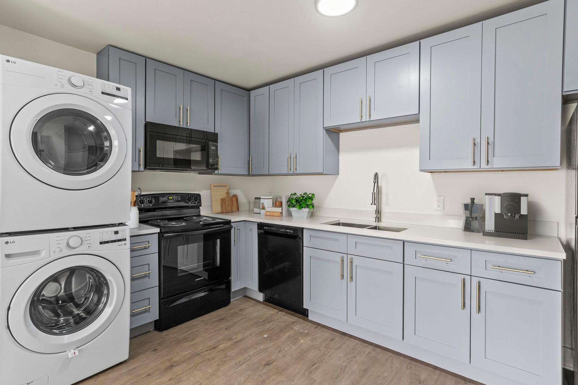 A kitchen with a washer and dryer stacked on top of each other.