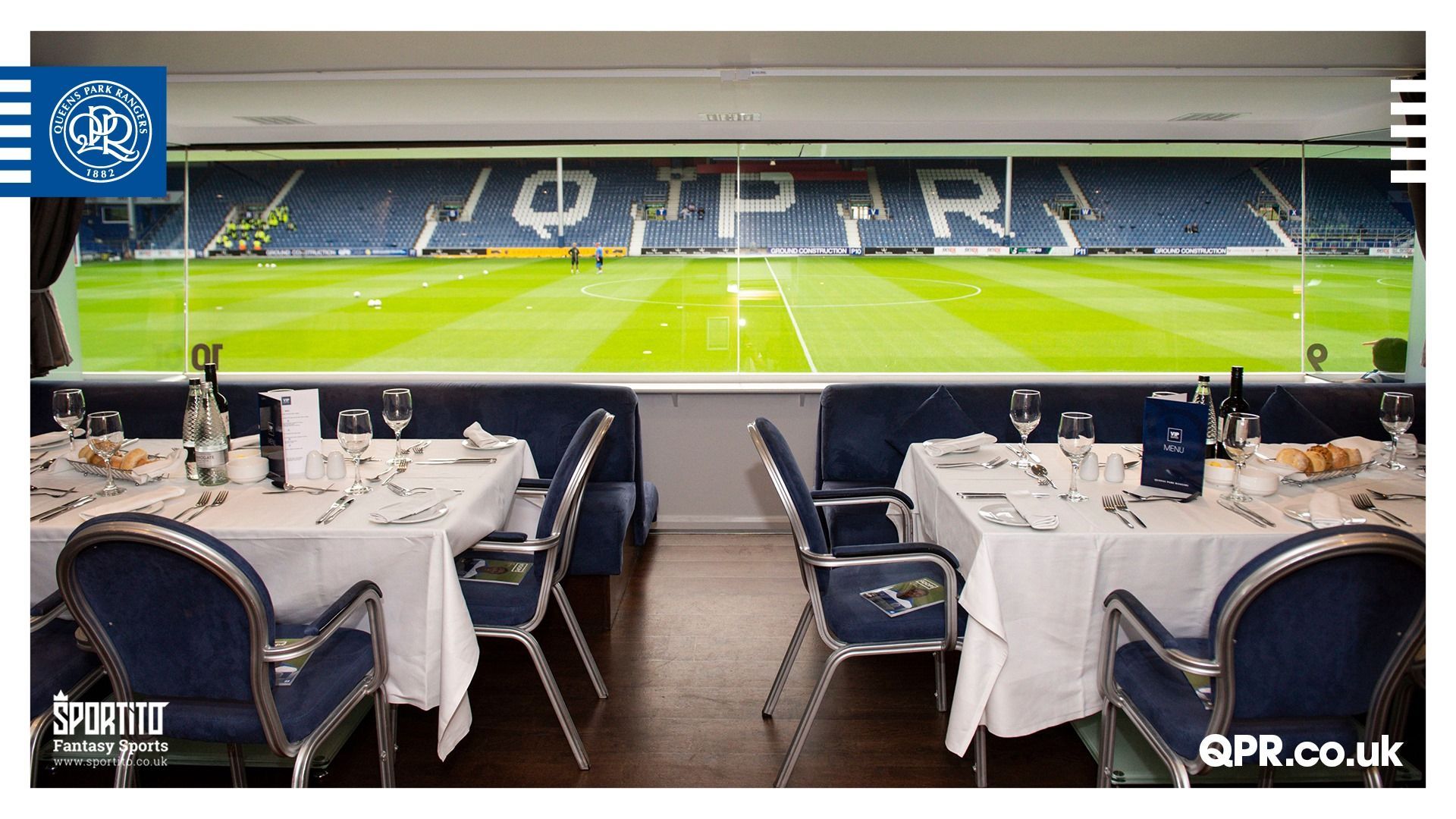 Dining tables overlooking a bright green football pitch with blue-and-white stadium seats spelling QPR