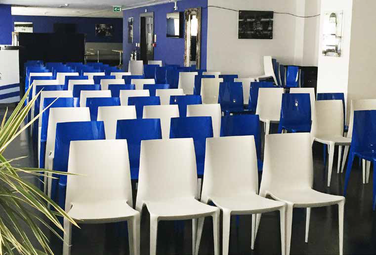 Rows of blue and white chairs arranged in a waiting room or lobby