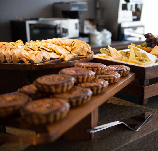 Bakery buffet with pastries and sliced bread on wooden trays at a counter