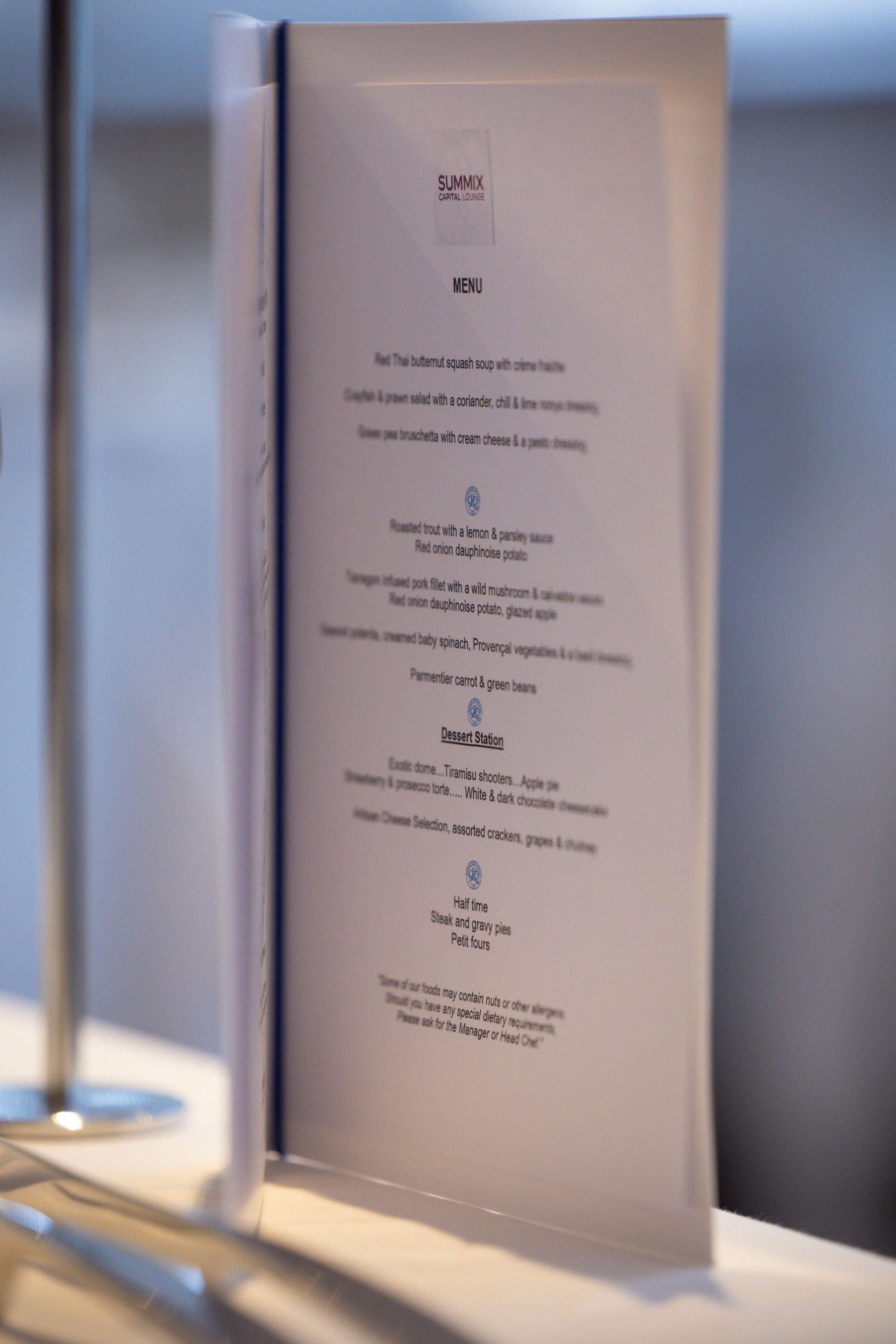 White folded menu standing on a table beside a lamp in a softly lit restaurant interior