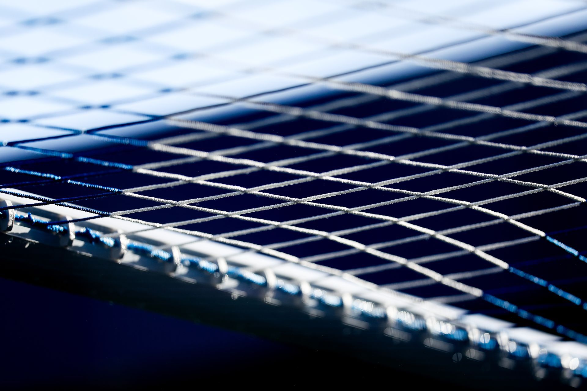 Close-up of a metal wire mesh with blue lighting and a blurred background
