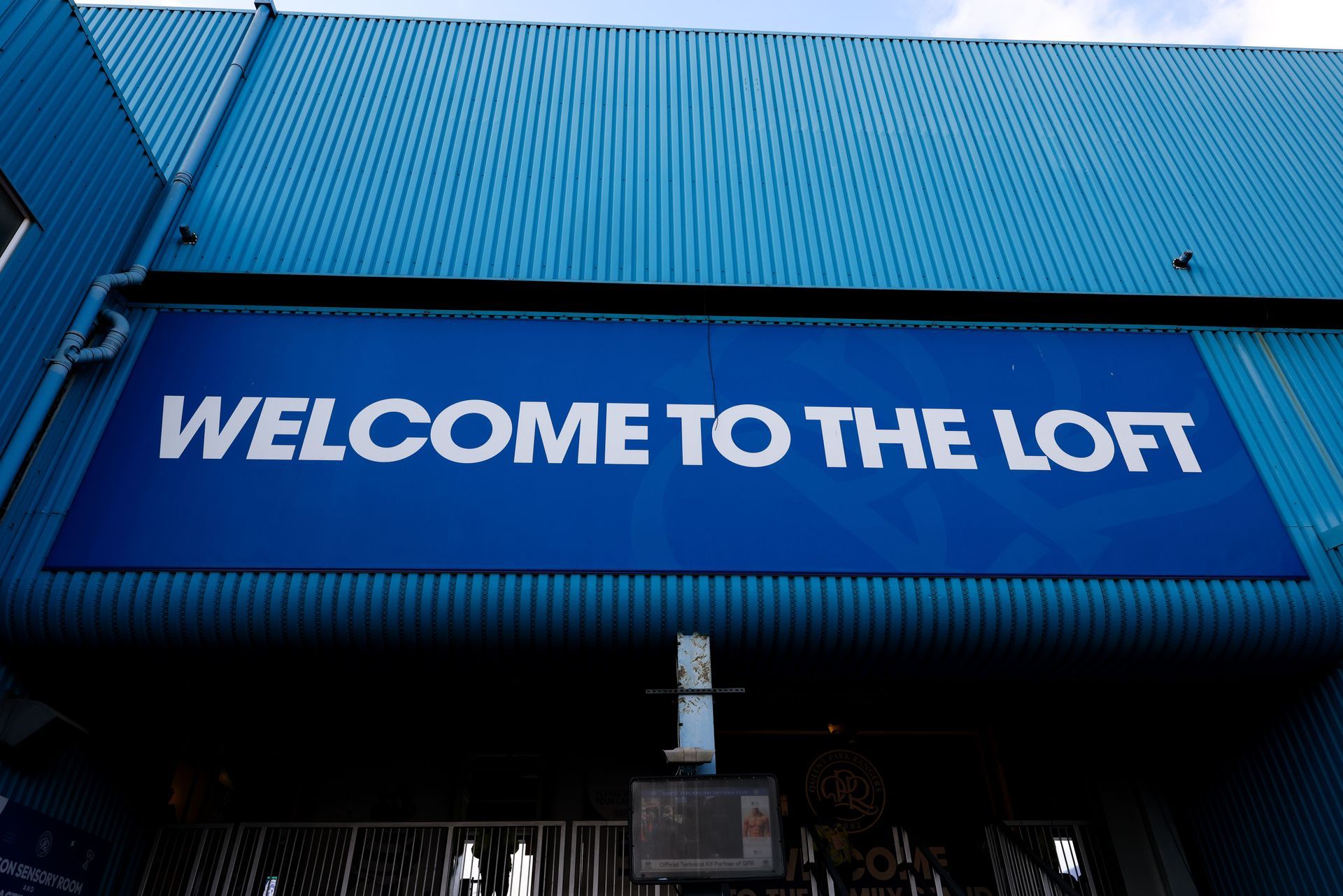 Blue building facade with a banner reading “WELCOME TO THE LOFT”